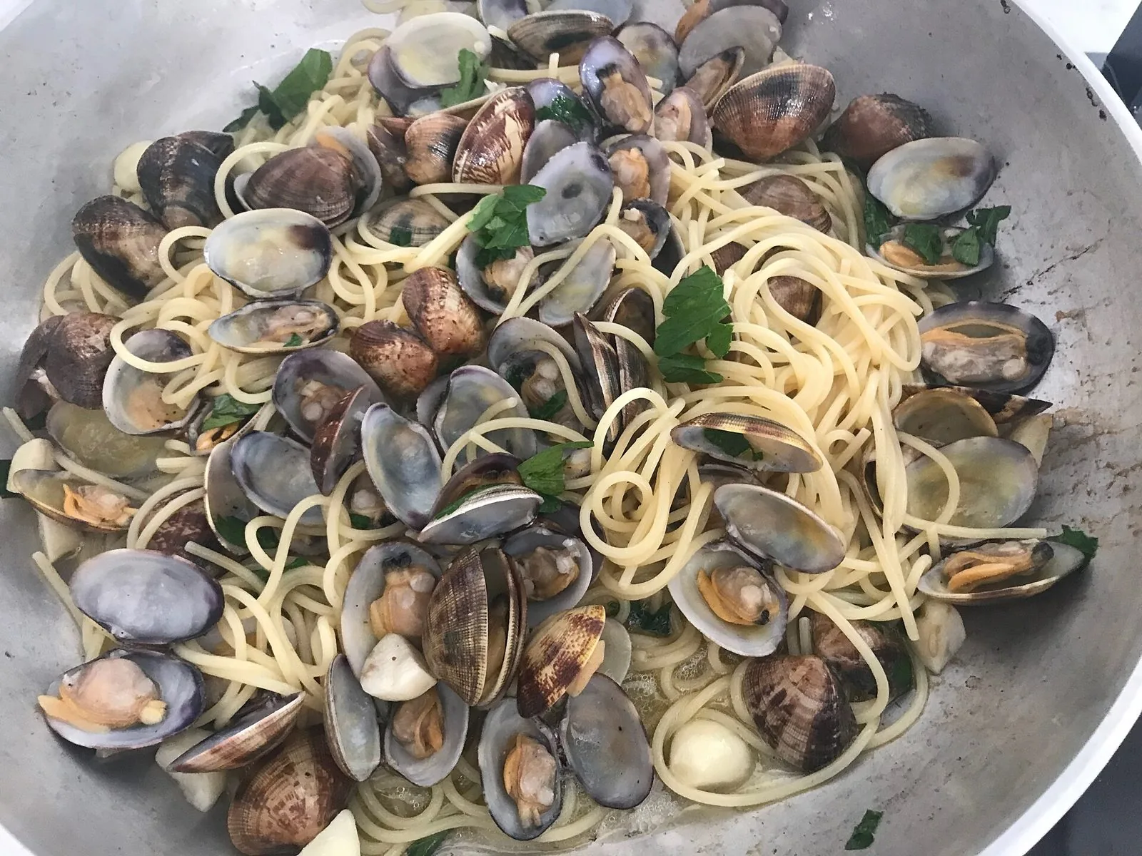 Spaghetti con vongole e prezzemolo appena cotti in padella